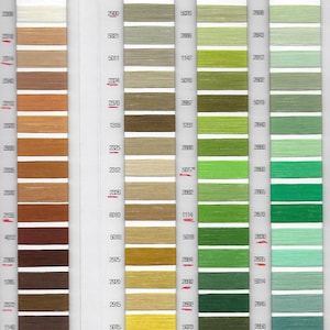 May include: A color chart of thread samples, with 18 rows of thread spools. The chart is divided into three sections, each with a different color scheme. The first section is beige and brown, the second is green and yellow, and the third is green and blue. Each thread spool has a number printed on it.