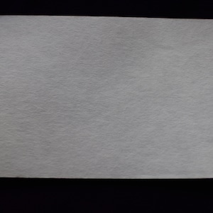 May include: A plain white sheet of paper with a slightly textured surface.