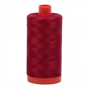 May include: A spool of deep red thread with an orange plastic bobbin.