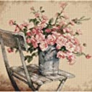 May include: A bouquet of pink roses in a gray metal vase sits on a wooden chair.