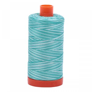 May include: A spool of teal and white striped thread with an orange plastic bobbin.