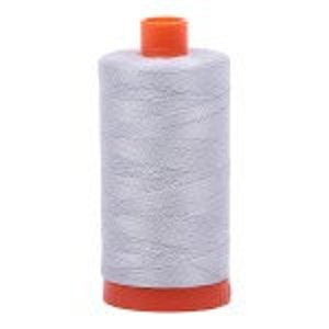 Puede incluir: Una bobina de hilo gris plateado con una bobina de pl&aacute;stico naranja.