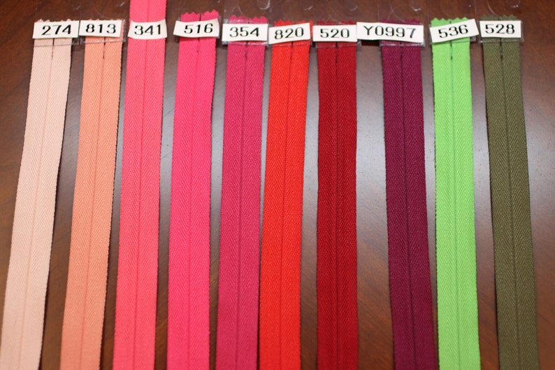 Puede incluir: Una selecci&oacute;n de diez cintas de cremallera en varios colores, incluyendo melocot&oacute;n, rosa, rojo, burdeos, verde y oliva. Las cintas de cremallera est&aacute;n etiquetadas con n&uacute;meros, incluyendo 274, 813, 341, 516, 354, 820, 520, Y0997, 536 y 528.