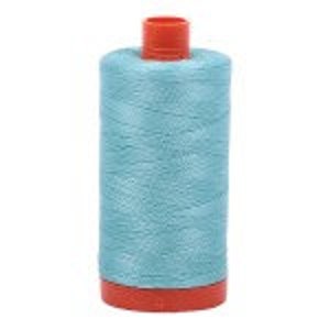 Puede incluir: Una bobina de hilo azul claro con una bobina de pl&aacute;stico roja.