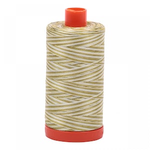 May include: A spool of gold and white thread with a red plastic top and bottom.