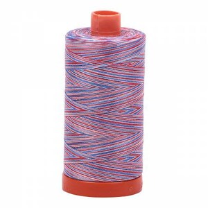May include: A spool of red, white, and blue striped thread. The thread is wound around a plastic spool with a red base.