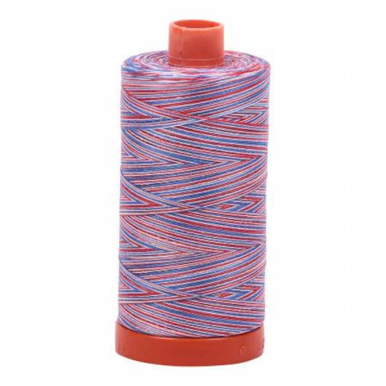 May include: A spool of red, white, and blue striped thread. The thread is wound around a plastic spool with a red base.