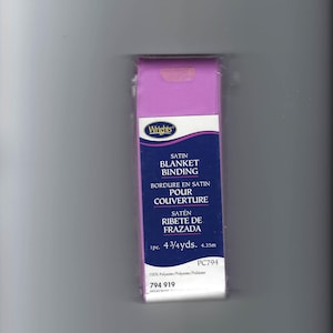 May include: A package of Wrights satin blanket binding in a light purple color. The packaging features the text Satin Blanket Binding, 1pc. 4 3/4 yds. 4.35m, PC794, 100% Polyester, and 794 919. The binding is wrapped in clear plastic packaging.