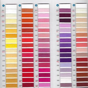 May include: A color chart of embroidery floss with a variety of colors, including yellow, orange, red, pink, purple, and beige. The chart is labeled with numbers and the brand name "Auril".