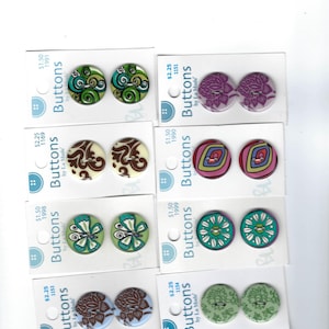 May include: Assortment of colorful buttons with various patterns, including floral, geometric, and abstract designs. The buttons are arranged on cards with the brand name "La Mode" and pricing information.