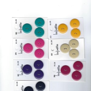 May include: Assortment of 10 packs of two-button sets in various colors, including teal, pink, beige, purple, and navy blue. Each pack is labeled with the brand name "la-petite" and a price of $1.25.