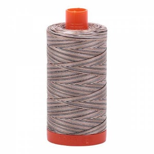 May include: A spool of brown and white striped thread with an orange plastic top and bottom.