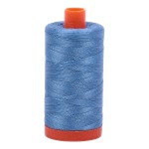 May include: A spool of light blue thread with a red plastic bobbin.