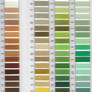 Puede incluir: Una carta de colores de muestras de hilo, con 18 filas de carretes de hilo. La carta est&aacute; dividida en tres secciones, cada una con un esquema de color diferente. La primera secci&oacute;n es beige y marr&oacute;n, la segunda es verde y amarilla, y la tercera es verde y azul. Cada carrete de hilo tiene un n&uacute;mero impreso en &eacute;l.