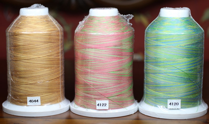 Puede incluir: Tres carretes de hilo para bordar, uno dorado, uno rosa y verde, y uno azul y verde. Los carretes est&aacute;n etiquetados con los n&uacute;meros 4044, 4122 y 4120.