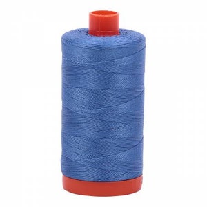 Puede incluir: Una bobina de hilo azul con una bobina de pl&aacute;stico roja.