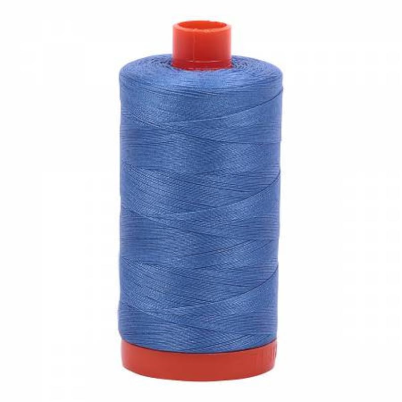 Puede incluir: Una bobina de hilo azul con una bobina de pl&aacute;stico roja.