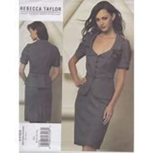 May include: A gray skirt suit with a short-sleeved jacket featuring a button closure, a pointed collar, and a decorative detail on the front. The skirt is fitted and has a straight silhouette.
