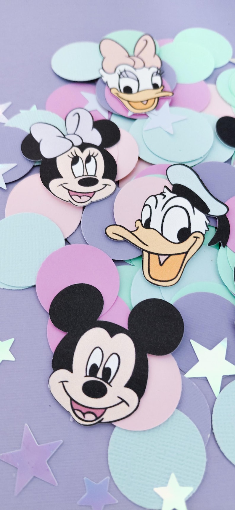 Puede incluir: Recortes de personajes de Disney, incluyendo Mickey Mouse, Minnie Mouse, Donald Duck y Daisy Duck, se encuentran entre confeti de colores pastel y decoraciones en forma de estrella. Los personajes sonr&iacute;en, creando un tema alegre y juguet&oacute;n.