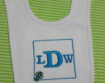 May include: White baby bib with a blue airplane and the letters "LDW" embroidered in a blue square.
