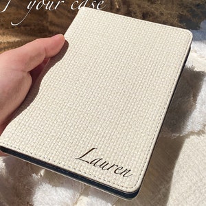 May include: A white passport holder with a woven texture and the name "Lauren" embossed in black lettering.