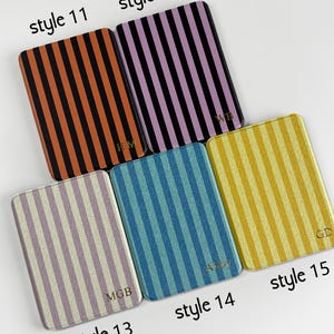 May include: Five rectangular coasters with vertical striped patterns in various colours: orange and black, purple and black, light purple and white, blue and light blue, and yellow and gold. Each coaster is labelled with a style number.