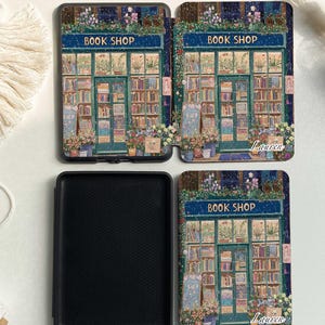 May include: A black and blue book cover with a colorful illustration of a bookstore with the text "Book Shop" and the name "Lauren" on the front. The back of the cover is black. The inside of the cover is black with a textured surface.