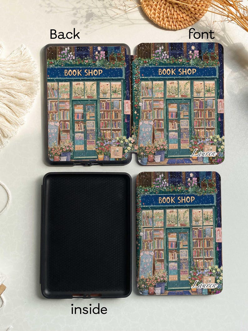 May include: A black and blue book cover with a colorful illustration of a bookstore with the text "Book Shop" and the name "Lauren" on the front. The back of the cover is black. The inside of the cover is black with a textured surface.