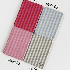 May include: Four rectangular cases with vertical striped patterns in red, pink, blue, and grey. Each case has a different initial or name printed on it. The text "style 01", "style 02", "style 03", and "style 04" are printed on the image.