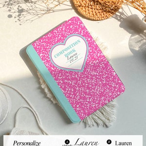 May include: A pink and blue composition book case with a heart design and the text "COMPOSITION BOOK Lauren 08.21".
