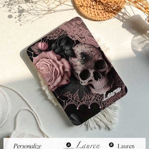 May include: A black laptop case with a pink and black skull and rose design. The case has a spider web pattern and the name "Lauren" is printed on the bottom right corner.