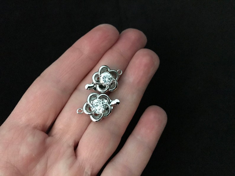 Two 12 mm Rhodium Plated and CZ Twisted Flower Tab Clasp