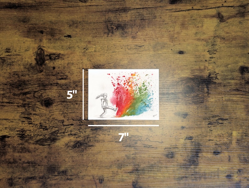 May include: A 5" x 7" watercolor painting on white paper. The artwork depicts a stick figure kicking a colorful splash of red, orange, yellow, green, and blue paint. The painting is on a wooden surface.