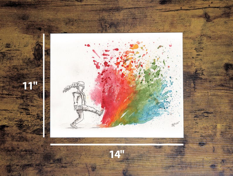 May include: An 11 x 14 inch watercolor print depicts a figure kicking a burst of colorful paint. The paint explosion transitions from red to orange, green, and blue. The figure is drawn in black and white, with a dynamic pose.