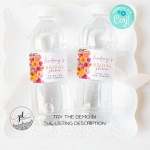 May include: Two clear plastic water bottles with labels featuring floral designs and the text "Lindsay's Bridal Shower." The labels include pink, orange, and yellow flowers. The bottles are on a white decorative tray. The text "Thank you for coming!" is also on the label.