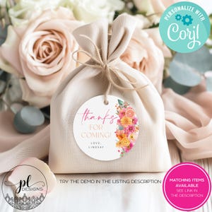 May include: A beige fabric gift bag tied with twine, featuring a round tag with floral and citrus designs. The tag reads "thanks for coming!" and "love, Lindsay". Additional text includes "Personalize with Corjl" and "Matching items available see link in the description."