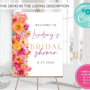 May include: A white sign on an easel, decorated with watercolor flowers and citrus slices. The sign reads "Welcome to Lindsay's Bridal Shower" with the date 6.27.2026. Additional text includes "Try the demo in the listing description" and size options.