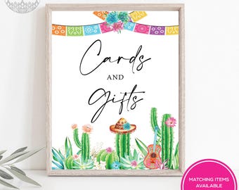 May include: A framed sign with the words "Cards and Gifts" in elegant script. The design features watercolor cacti, a sombrero, and a guitar. Colorful papel picado banners and floral accents adorn the top, with a pink circle at the bottom that says "Matching Items Available".