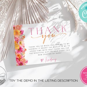 May include: A white card with the words "THANK YOU" in pink and orange script. The card is decorated with a floral design of pink and orange flowers and citrus slices. Text on the card reads "Thank you so much for coming to my shower!" and "Lindsay".