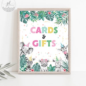May include: A framed sign with the words "CARDS & GIFTS" in colorful letters. The sign features watercolor illustrations of safari animals wearing party hats and surrounded by tropical leaves and flowers.