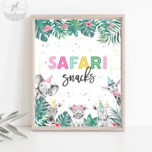 May include: A framed print with the words "SAFARI snacks" in colorful letters. The print features watercolor illustrations of safari animals wearing party hats and surrounded by tropical leaves and flowers.