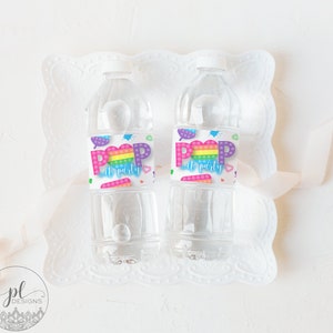 May include: Two clear plastic water bottles with colorful labels that say "Pop It Party". The labels feature a rainbow heart design with a pop it toy pattern.