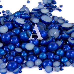 May include: A large pile of blue pearl beads, some whole and some cut in half, with a white interior.