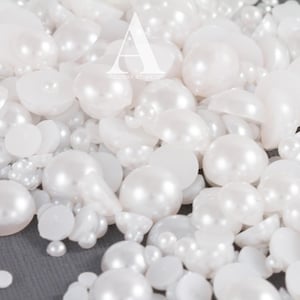 May include: A large assortment of white pearl-like embellishments, some round and some flat, in various sizes.