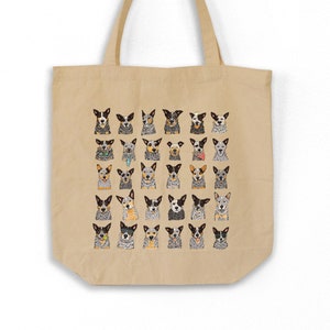 May include: A beige canvas tote bag with a colorful pattern of Australian Shepherd dogs. The dogs are all different colors and have different expressions.