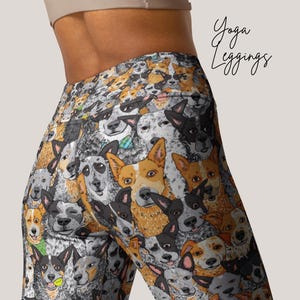 May include: Yoga leggings with a colorful pattern of Australian Shepherd dogs. The leggings are black with a variety of dog breeds in different colors and poses.