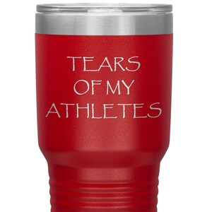 May include: Red stainless steel tumbler with a white inscription that reads "Tears of my Athletes".