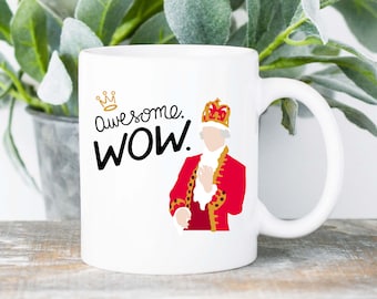 May include: White ceramic mug with a cartoon image of a man wearing a red and gold costume and a crown. The text "Awesome WOW." is printed on the mug.