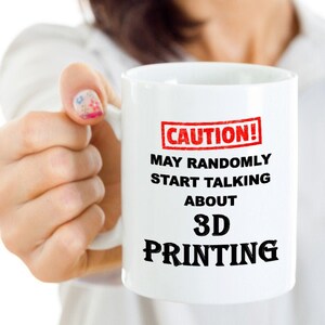 May include: White ceramic mug with a red and black warning sign that reads "CAUTION! MAY RANDOMLY START TALKING ABOUT 3D PRINTING".
