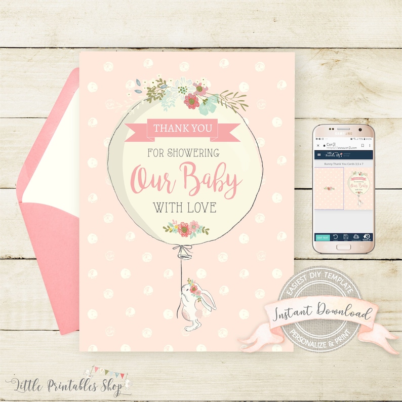 May include: A baby shower thank you card with a pink envelope. The card features a balloon design with the text "Thank You For Showering Our Baby With Love." A small bunny is attached to the balloon. The card is decorated with floral accents.